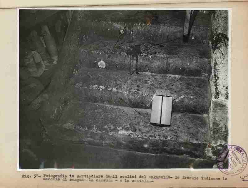 Dettaglio delle scale del bar che portano al magazzino, con le macchie di sangue e la cartuccia del proiettile